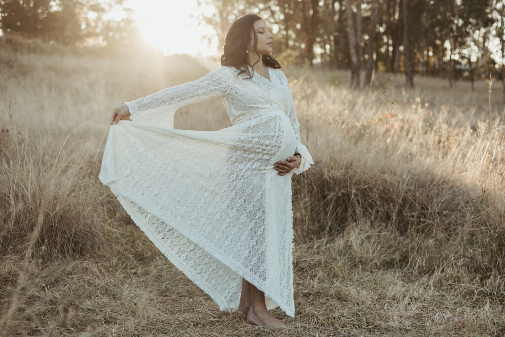 Pregnant Sydney mum in a gorgeous white lace robe at sunset for her Maternity Celebration photoshoot.
